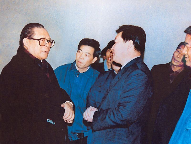 1991年2月5日，时任中共中央总书记的江 泽 民（左一）视察利来国际，他指示：“抓住机遇，深化改革，扩大开放，促进发展，保持稳定。”